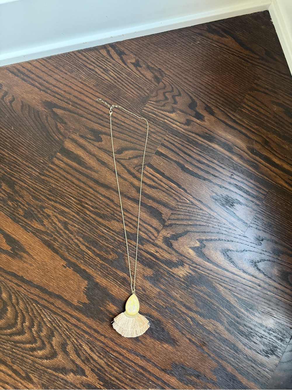 Gold-tone necklace with a fan-shaped tassel fringe and sparkly teardrop stone